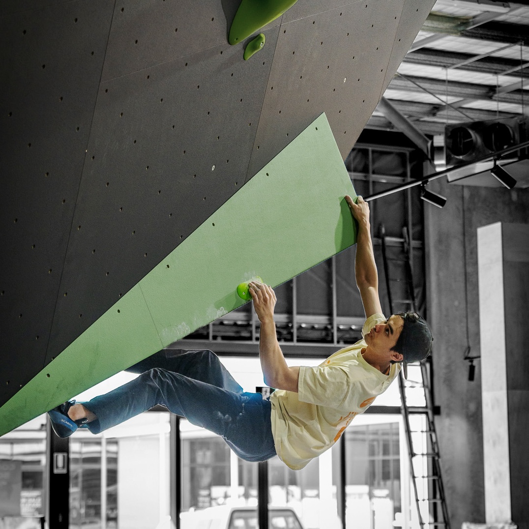 Gus.G1.2.L_ICP Volume - Climb ICP Shop Australia Climber pulling on a green Gus.G1.2.L ICP Volume mounted to a climbing wall