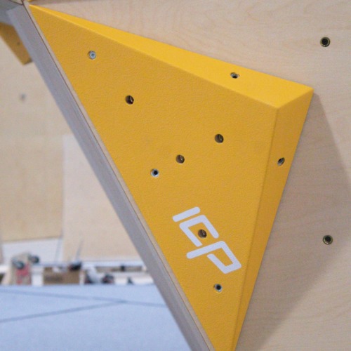 Yellow ICP Johno J1.3 XS climbing volume mounted on a wood-textured wall, positioned for use with ICP Raps.
