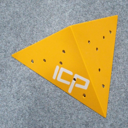 Yellow ICP Kai K1.2 S climbing volume viewed at an angle, resting on climbing safety matting before route setting.