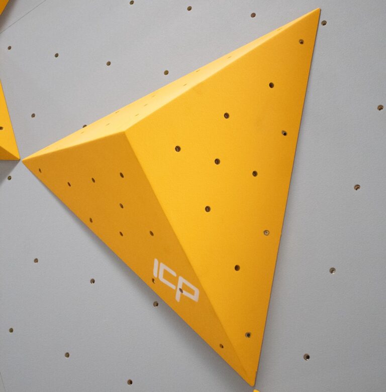 Yellow ICP Kai K1.1 S climbing volume viewed front-on, mounted on a grey textured climbing wall.