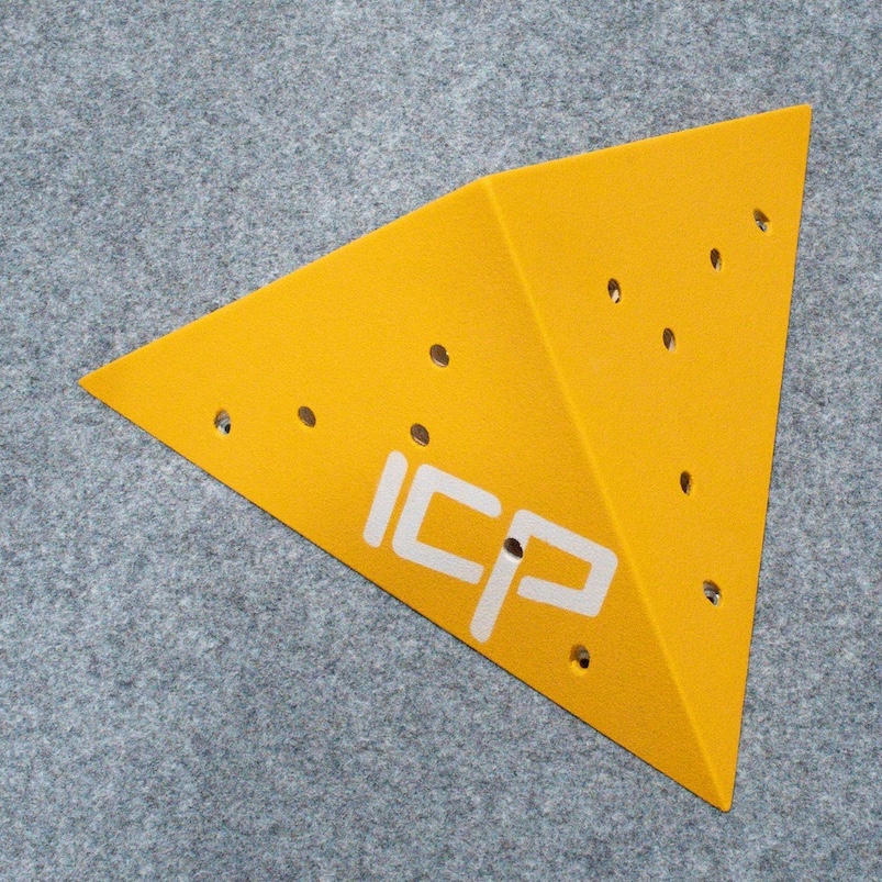 Yellow ICP Kai K1.2 S climbing volume viewed at an angle, resting on climbing safety matting before route setting.