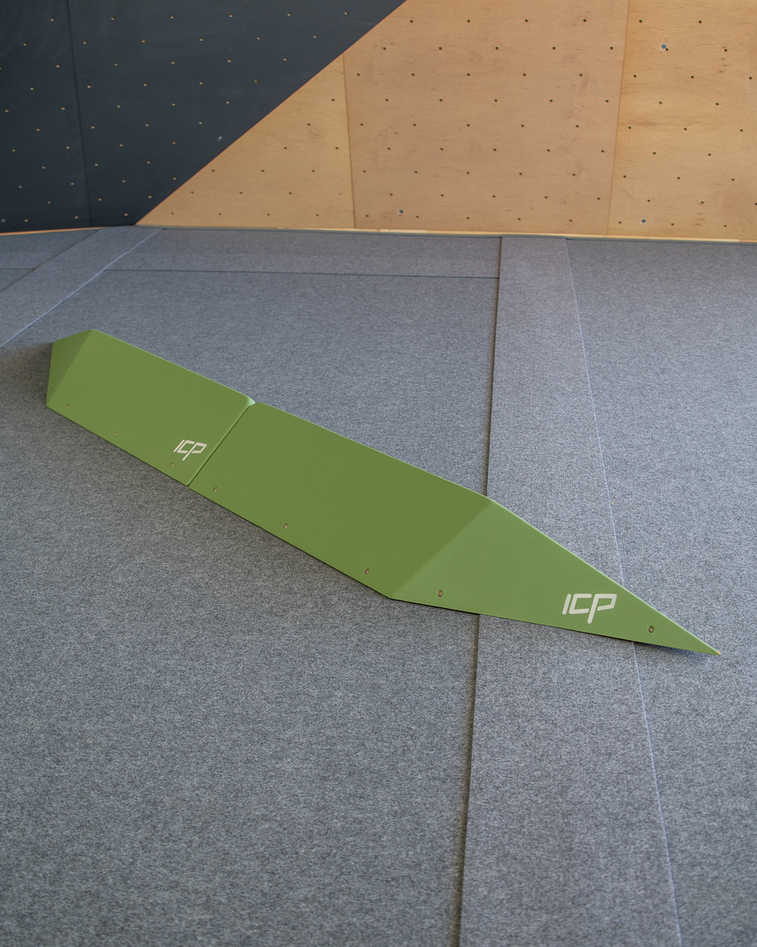 Large green ICP Harry H2.4-5 L thin rail climbing volume pair with t-nuts, mounted on a wood-textured wall for technical route setting.