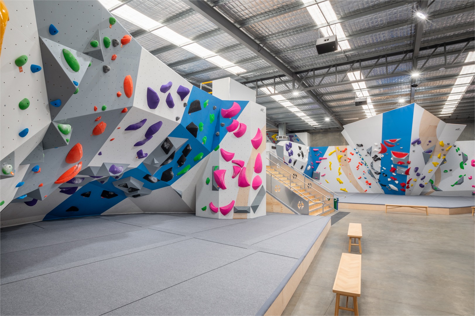 A large indoor climbing gym with many different climbing walls.