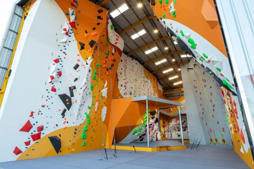 ICP Walls Rope and border climbing walls with safety mats and volumes – Byron Bay A bouldering gym with white, red and black paint work built by international climbing wall builder, ICP. The walls are filled with various colourful holds and volumes.