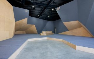 Cut Loose climbing walls freshly built by ICP with dark grey and wood textures, modern European design, and grey safety matting.