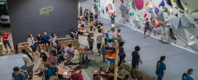 “Spectators and climbers gathered during an indoor bouldering event at an ICP-built climbing gym.”