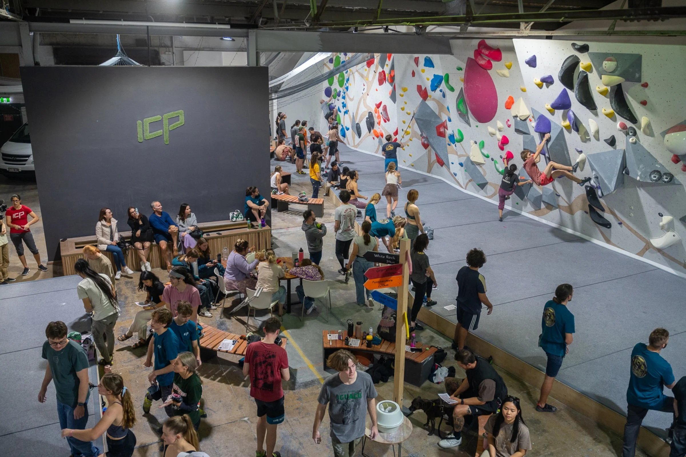 “Spectators and climbers gathered during an indoor bouldering event at an ICP-built climbing gym.”