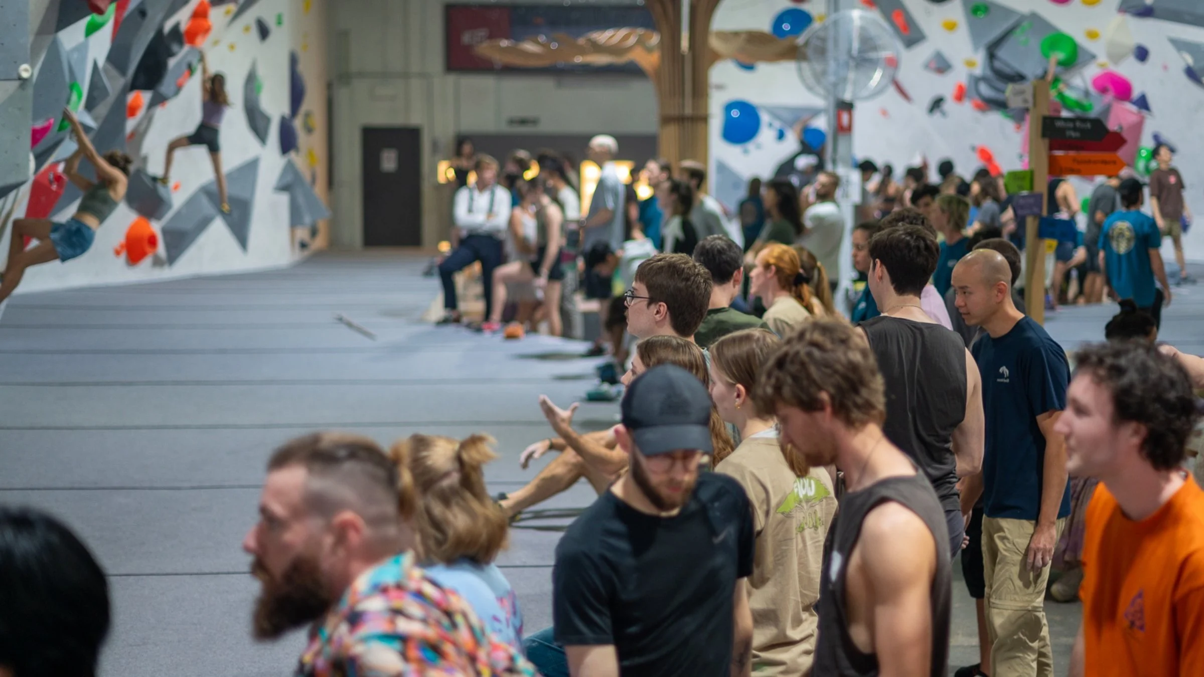 “Crowd watching climbers during an indoor bouldering competition at an ICP-built climbing gym.”