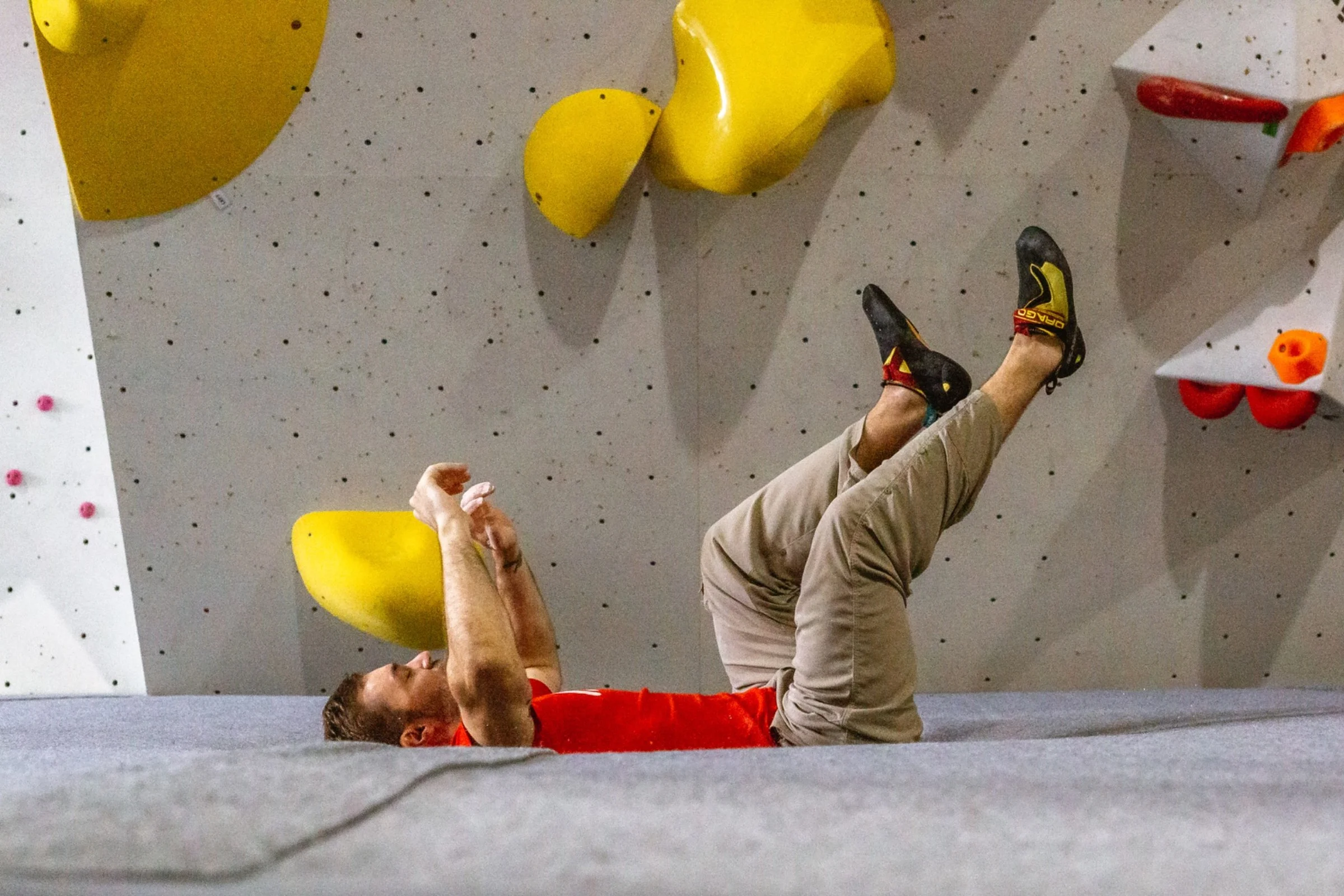 Climber falling safely onto ICP mats at an indoor bouldering gym