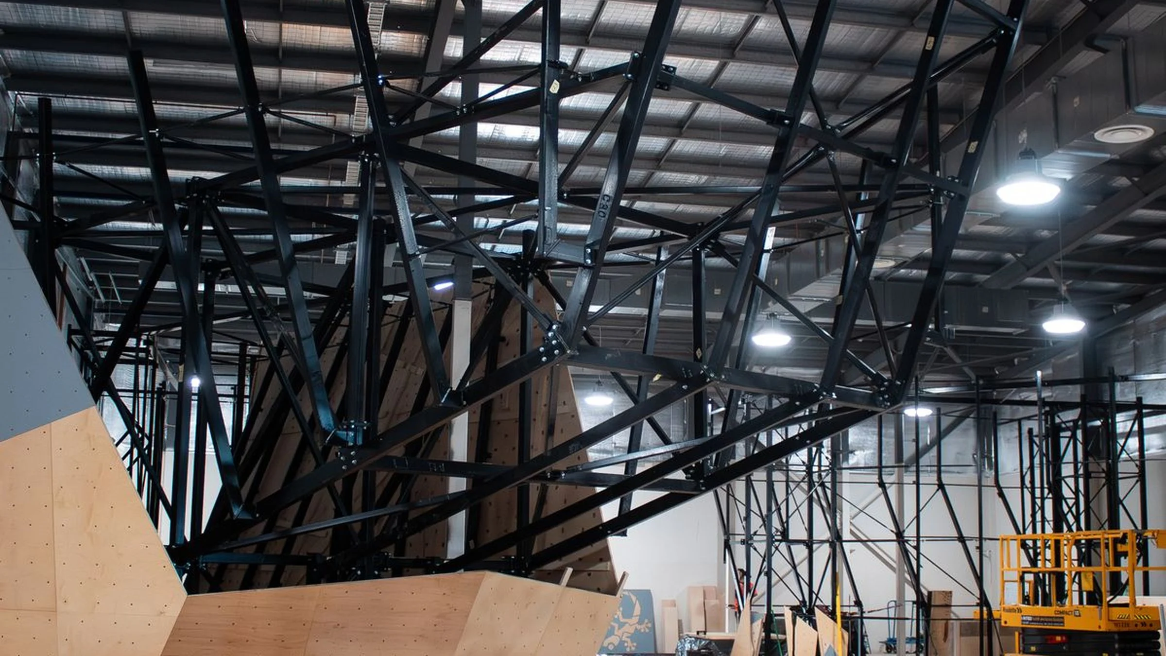 Large prow bouldering wall at Darwin Gekco Climb showing the engineered steel support framework and custom climbing wall construction during installation of the full mixed rope and boulder climbing gym